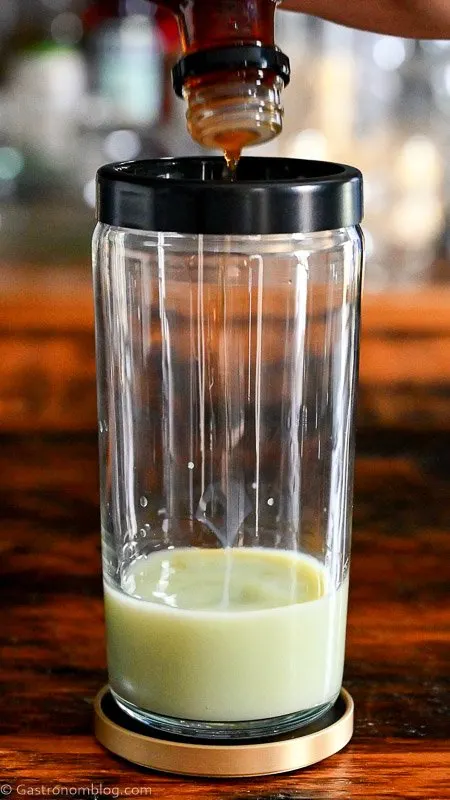 pistachio liqueur in a glass cocktail shaker