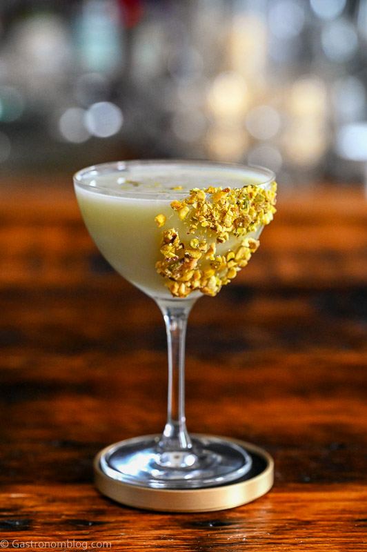 Light green Pistachio Martini Recipe in a coupe with pistachios on rim