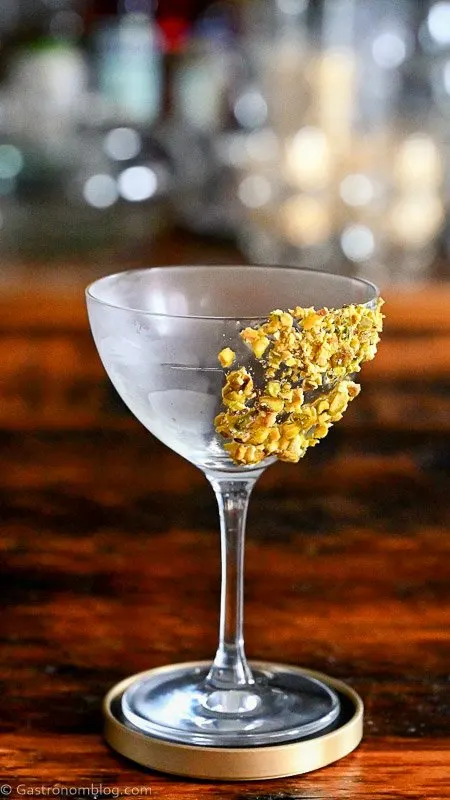 Light green Pistachio Martini Recipe in a coupe with pistachios on rim