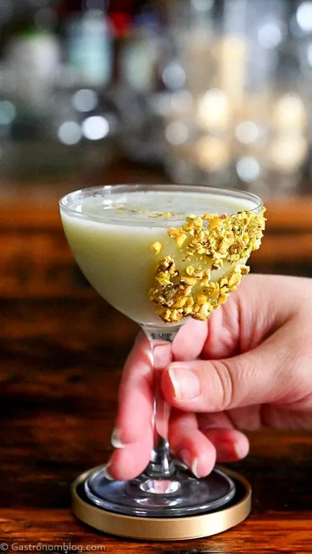 Light green Pistachio Martini Recipe in a coupe with pistachios on rim