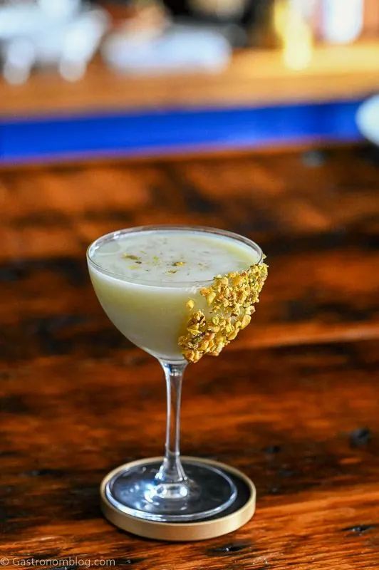 Light green Pistachio Martini Recipe in a coupe with pistachios on rim