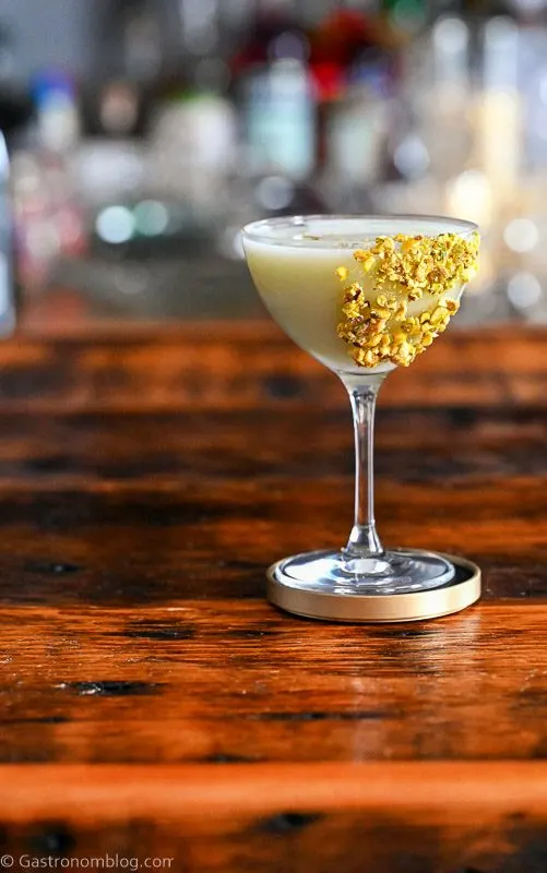 Light green Pistachio Martini Recipe in a coupe with pistachios on rim