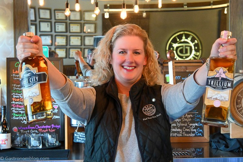 Sara, the owner of Trail Distilling Oregon holding bottles