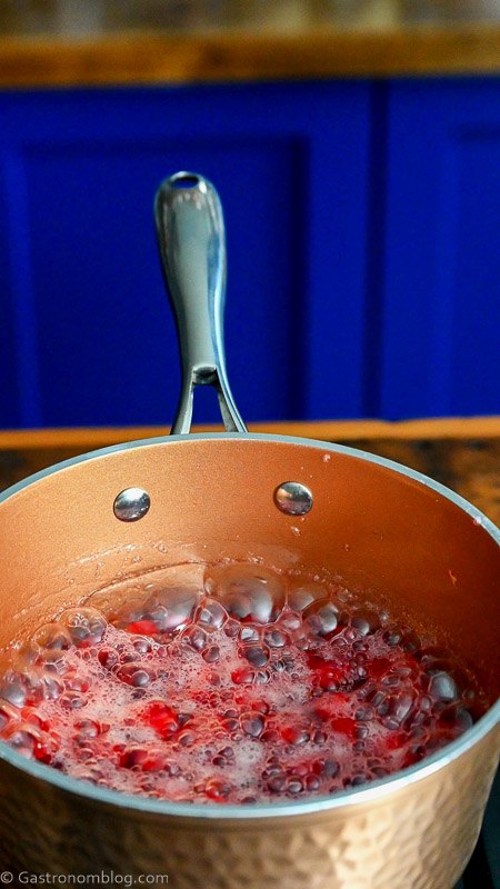 cranberry simple syrup being made in copper saucepan