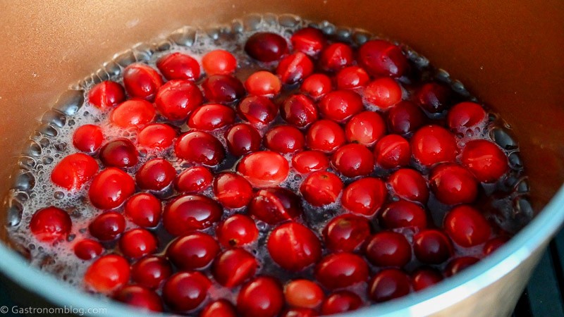 cranberries floating in syrup in copper saucepan