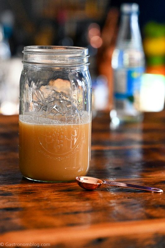 tan hazelnut orgeat in glass jar on wood table