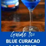 So what is blue curacao? This blue liqueur is in a cocktail coupe, and in a bottle behind on a wood table