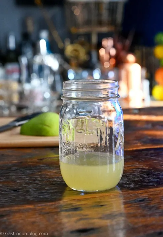 gold colored pear syrup in mason jar on wooden table