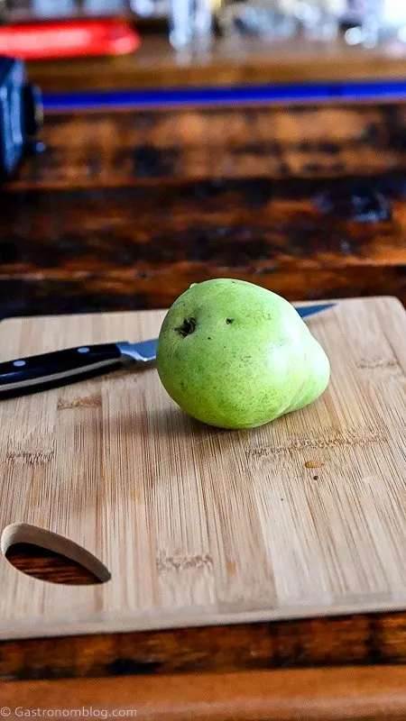pear on wooden cutting board with knife