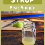 gold colored pear syrup in mason jar on wooden table