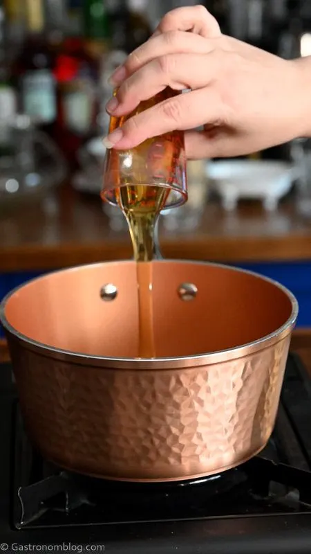 honey being poured into copper saucepan