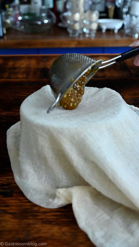 pistachio orgeat being put into cheesecloth