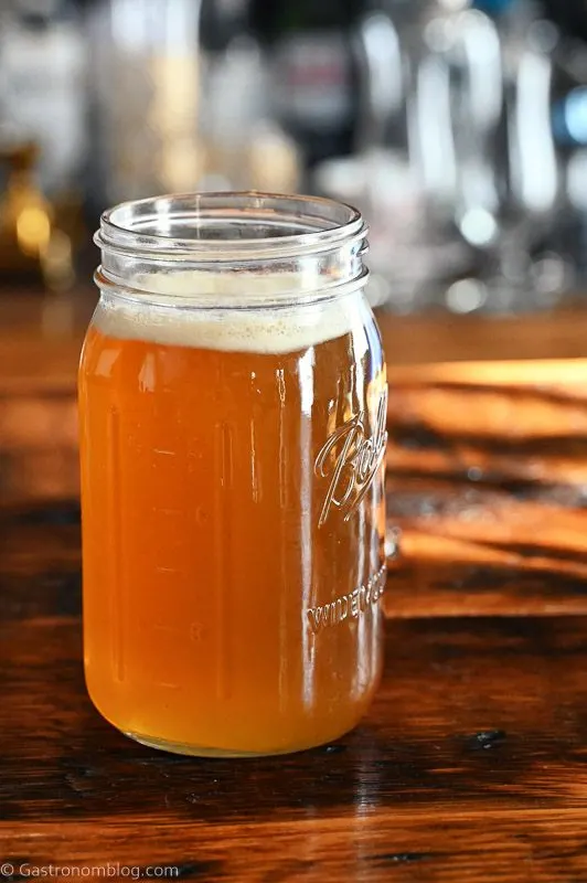 golden spiced honey syrup in a large jar on a wooden table