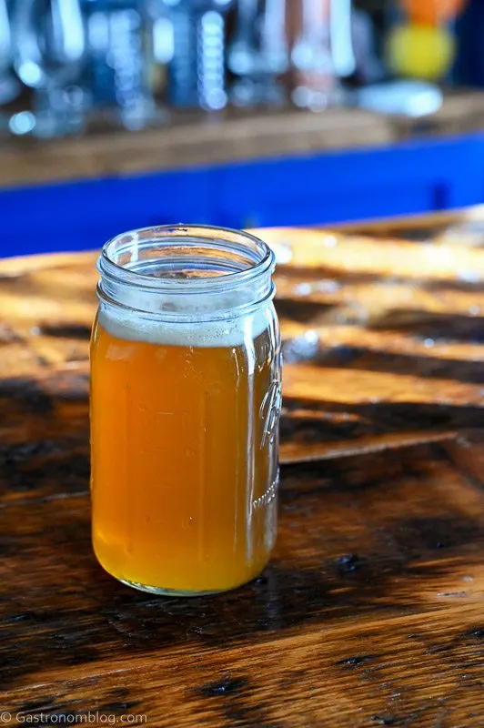 golden spiced honey syrup in a large jar on a wooden table