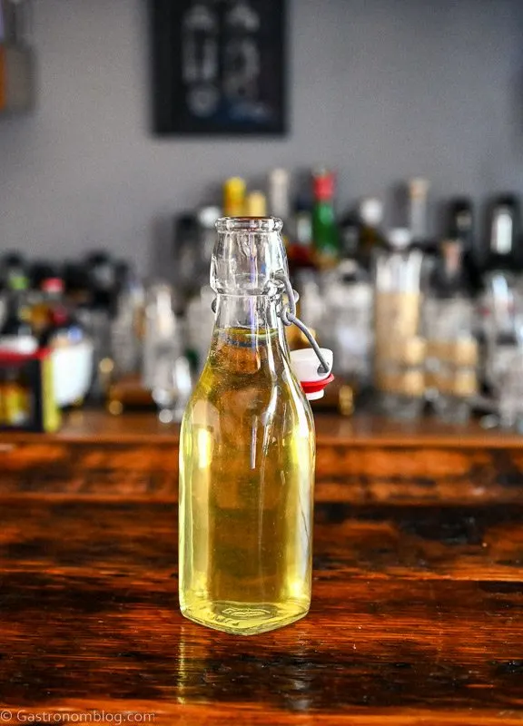 yellow colored Lemon Infused Vodka in swingtop bottle on wooden table