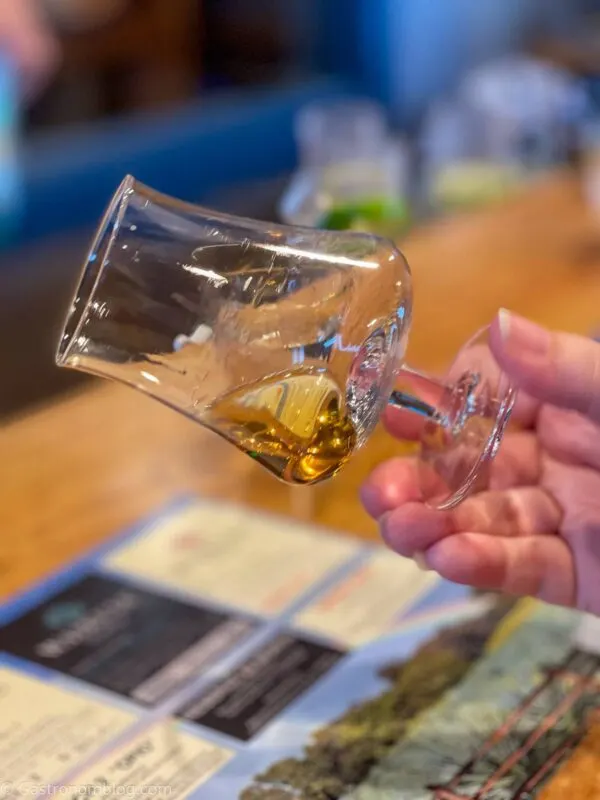 swirling aged agave spirits in glass at Waikulu Distillery on Maui