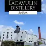 White distillery building at Lagavulin, on the isle of Islay, Scotland. Brick smokestack behind