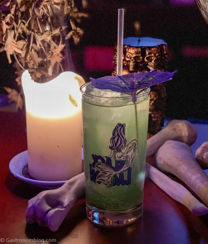 green cocktail in tumbler with a mermaid on it at Nite Owl's Black Lagoon Halloween Pop-up event