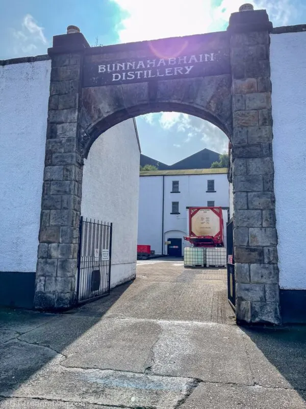 view through arch between white buildings during Bunnahabhain Distillery Tour