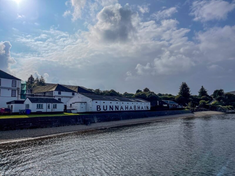 view of white buildings from pier at Bunnahabhain Distillery Tour