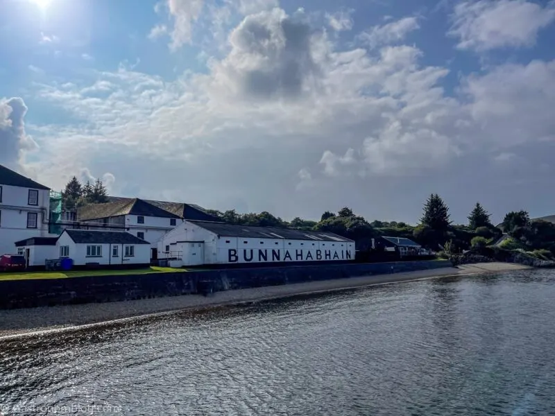 view of white buildings from pier at Bunnahabhain Distillery Tour