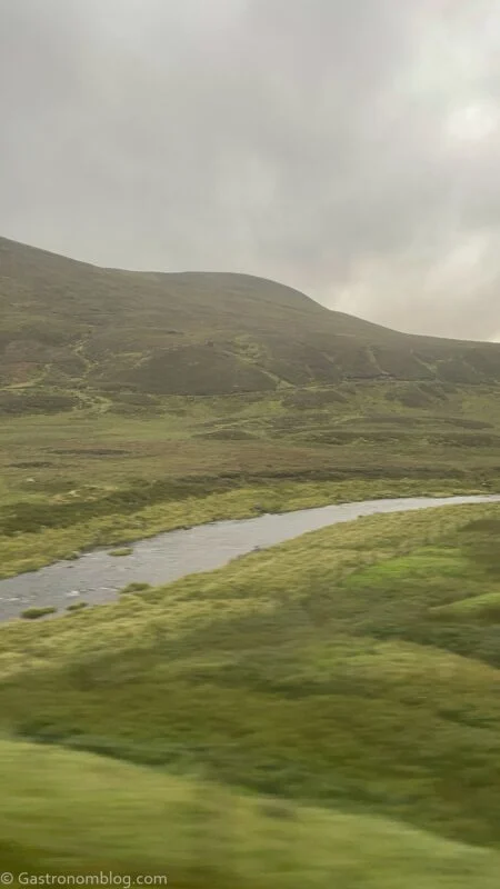highlands with stream from train car on Caledonian Sleeper Train