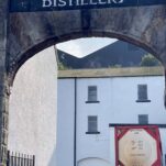 view through arch between white buildings during Bunnahabhain Distillery Tour