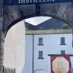 view through arch between white buildings during Bunnahabhain Distillery Tour