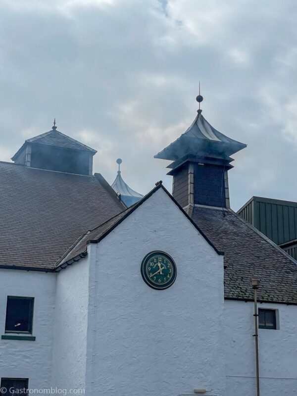 white building at Laphroaig Distillery with peat smoke coming out of chimney