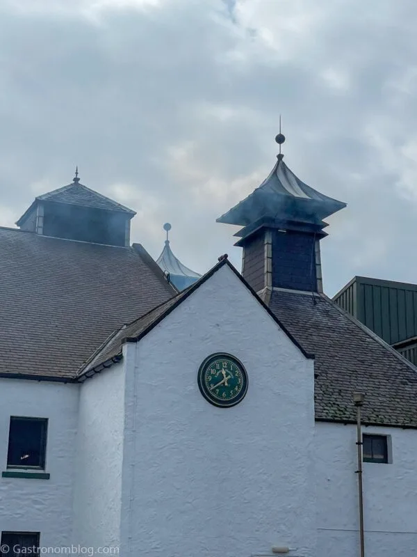 white building at Laphroaig Distillery with peat smoke coming out of chimney