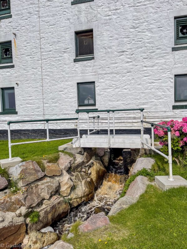white building at Laphroaig Distillery with bridge over rocks