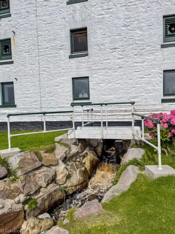 white building at Laphroaig Distillery with bridge over rocks